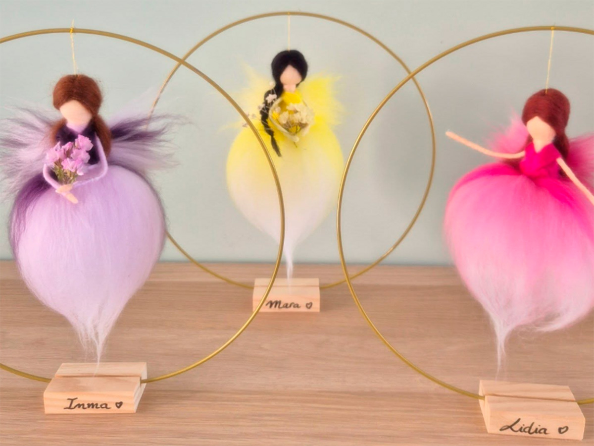 Tres hadas de lana en tonos lila, amarillo y rosa suspendidas en aros dorados